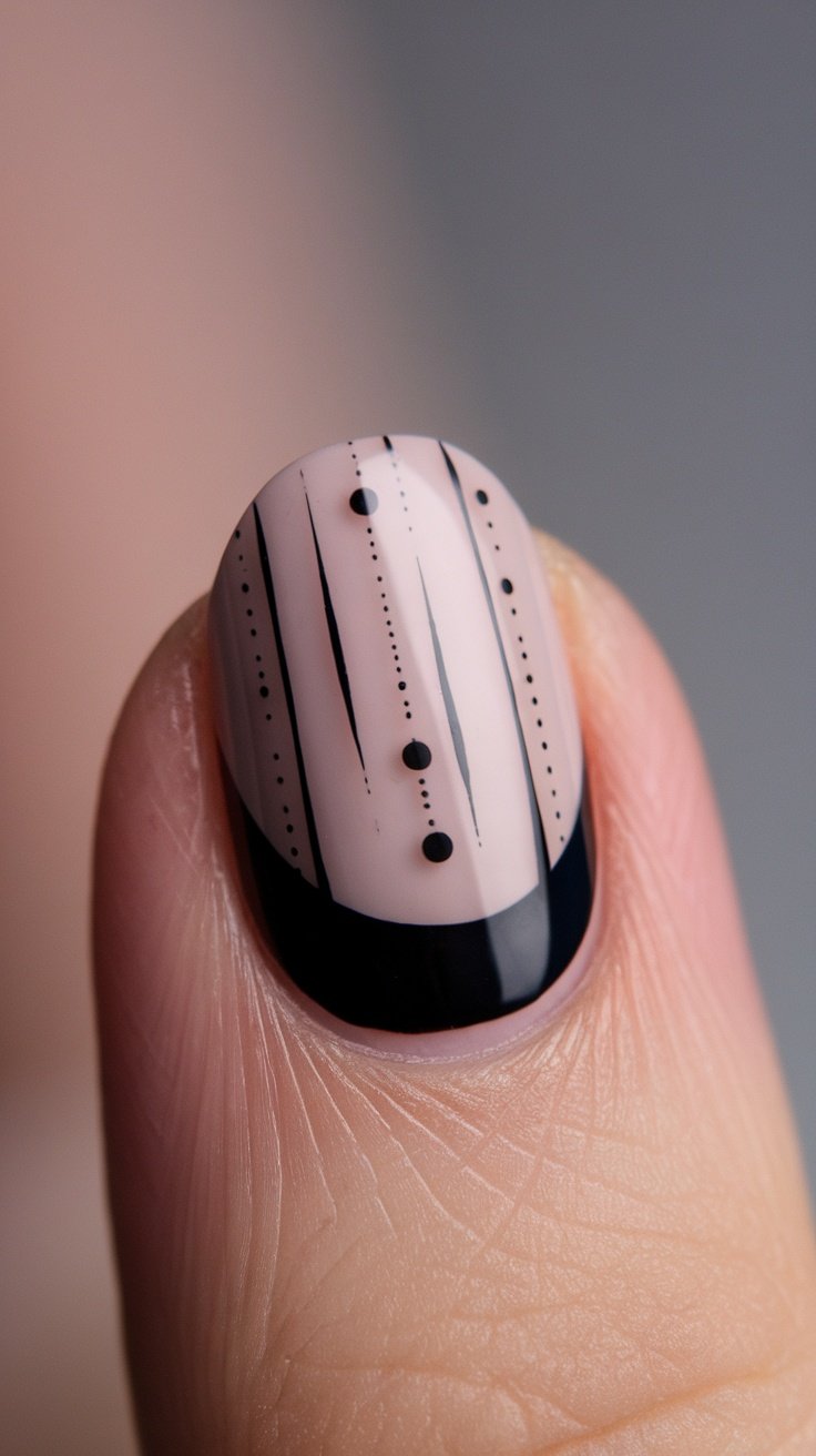 Minimalist nail design featuring pale pink base with black lines and dots.