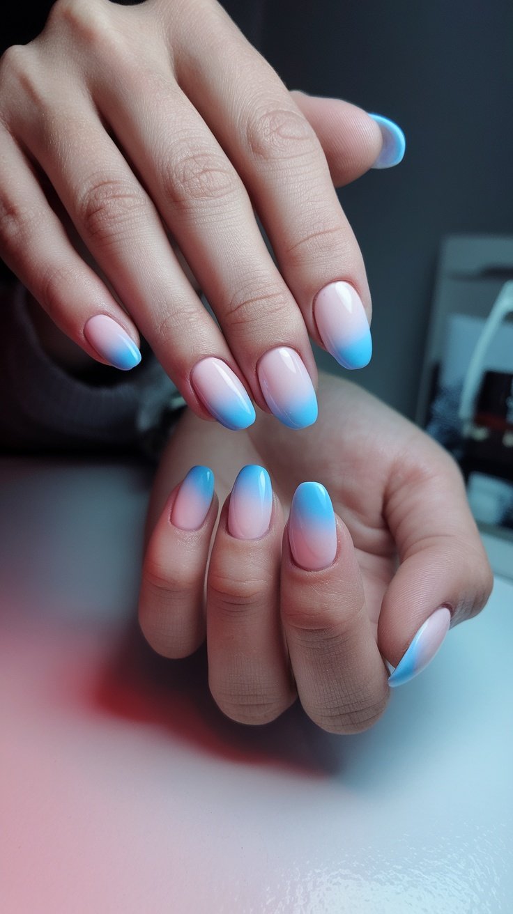 Pastel ombre nail design with blue and pink tones.